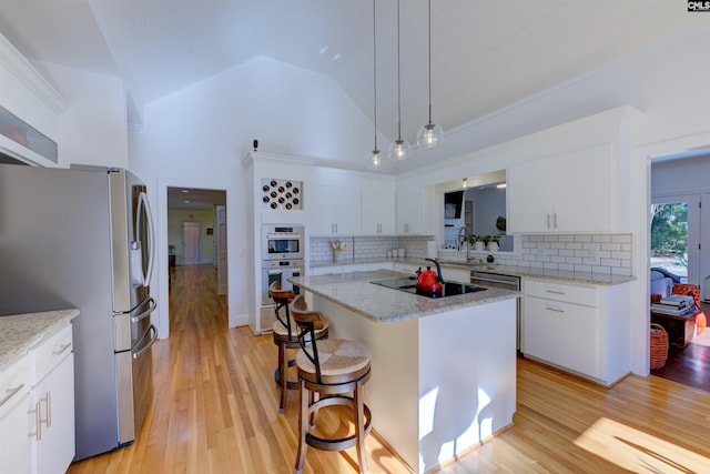 kitchen featuring pendant lighting, appliances with stainless steel finishes, a center island, and white cabinets