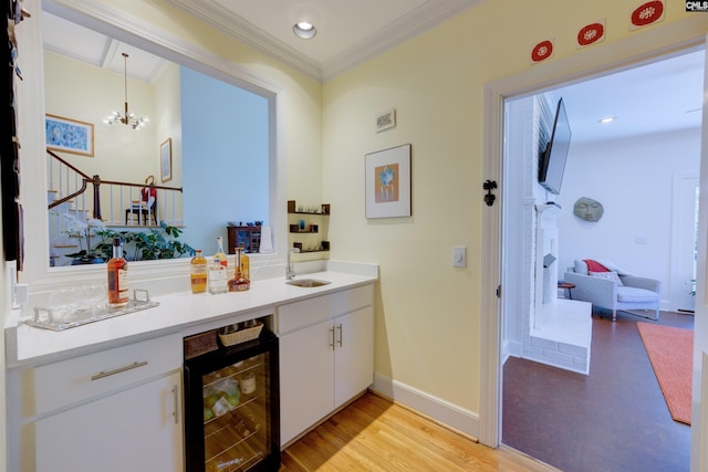 bar with white cabinets, sink, pendant lighting, and wine cooler