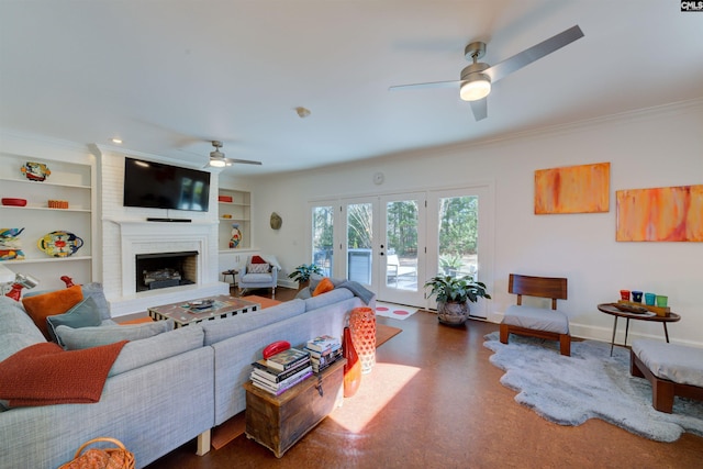 living room featuring ceiling fan, a fireplace, ornamental molding, built in shelves, and french doors