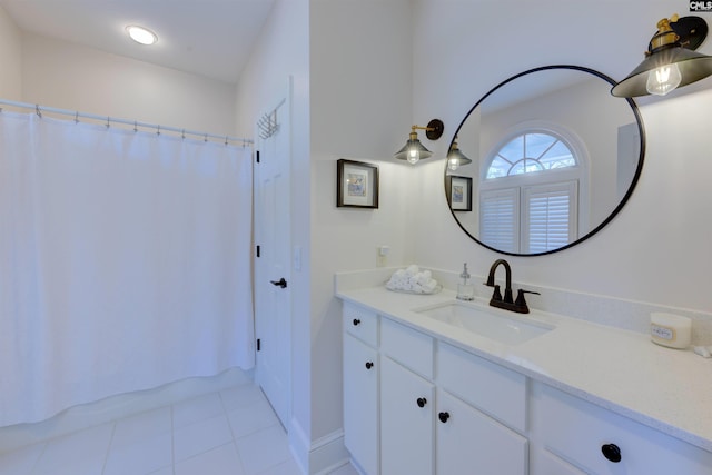 bathroom with tile patterned flooring, vanity, and walk in shower