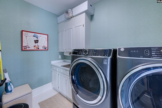 laundry area with cabinets and washing machine and clothes dryer