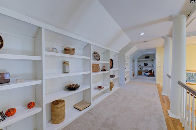 hall with lofted ceiling, light hardwood / wood-style flooring, built in features, and ornate columns