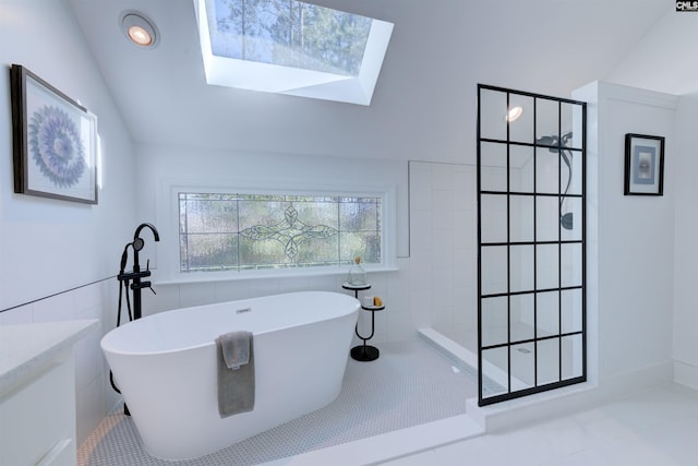 bathroom featuring tile patterned flooring, lofted ceiling with skylight, tile walls, and plus walk in shower