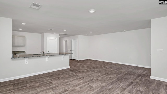 unfurnished living room with dark hardwood / wood-style floors and sink