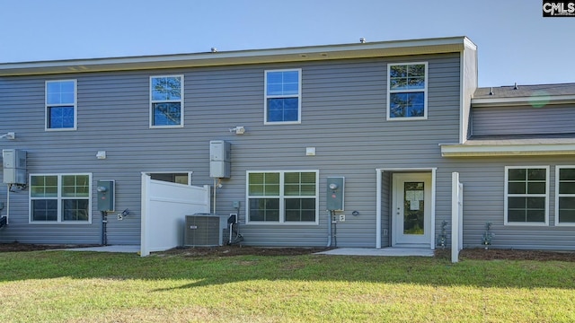 back of property with a yard and central air condition unit