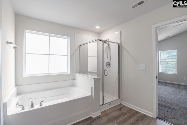 bathroom with wood-type flooring and separate shower and tub