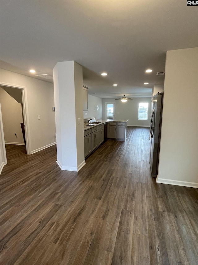 kitchen featuring dark wood-type flooring, sink, stainless steel refrigerator, gray cabinets, and ceiling fan