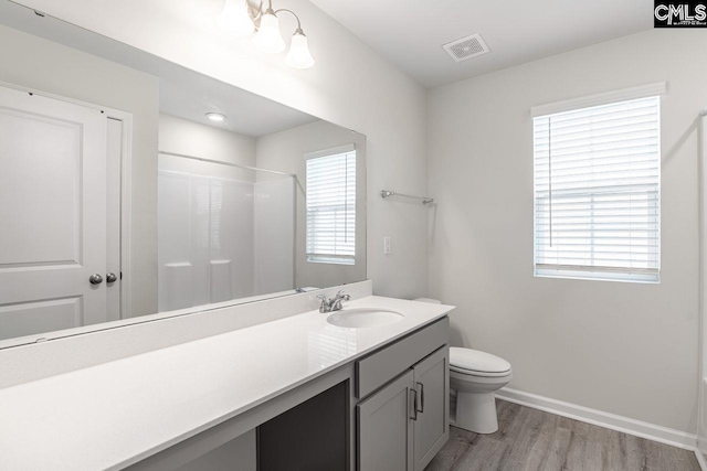 bathroom with hardwood / wood-style flooring, vanity, toilet, and walk in shower