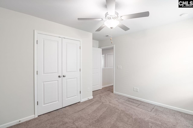 unfurnished bedroom featuring light carpet, ceiling fan, and a closet