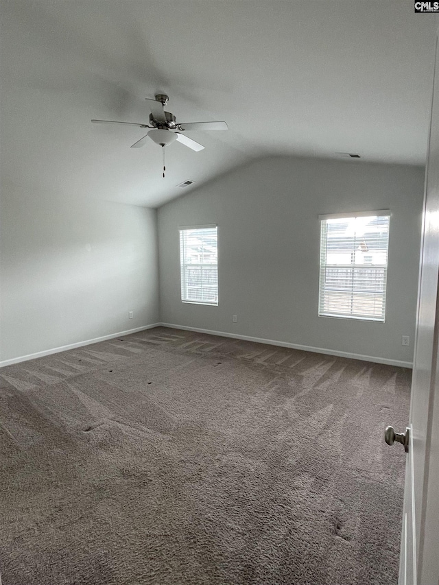 carpeted empty room with vaulted ceiling and ceiling fan