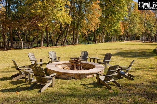 view of home's community with an outdoor fire pit and a lawn