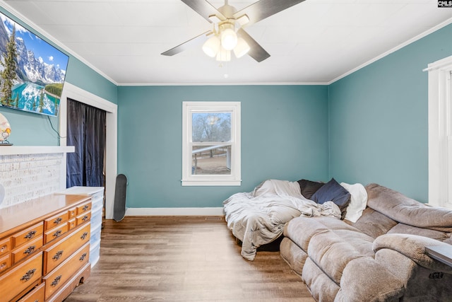 bedroom with ornamental molding, hardwood / wood-style floors, and ceiling fan