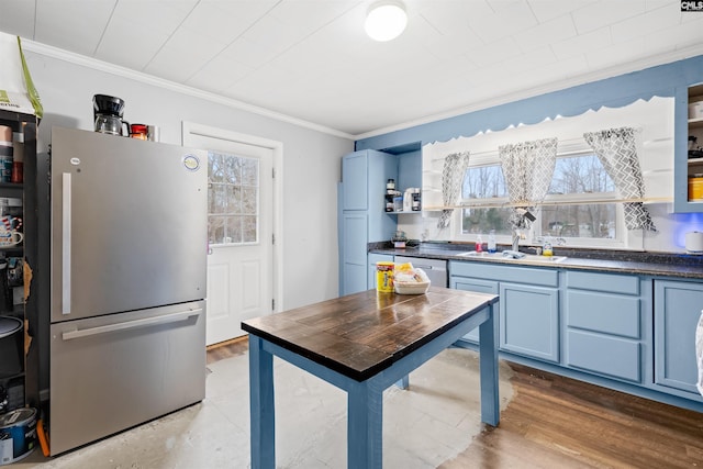 kitchen featuring hardwood / wood-style flooring, ornamental molding, stainless steel appliances, and blue cabinets