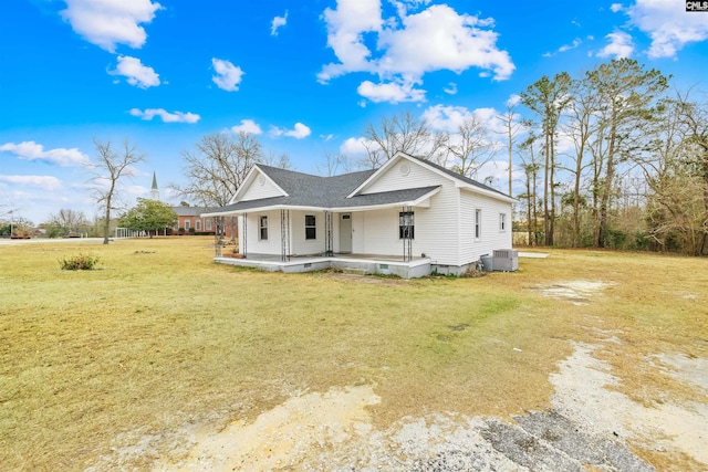 view of front of home featuring cooling unit, a front lawn, and covered porch