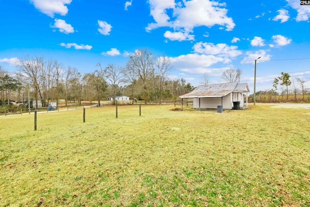 view of yard with an outbuilding and a rural view