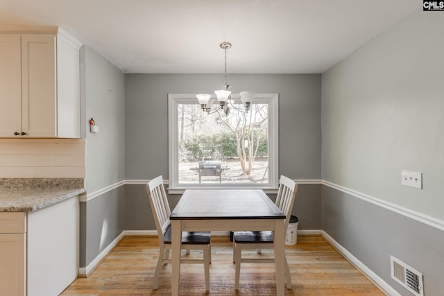 dining room with a notable chandelier and light hardwood / wood-style flooring