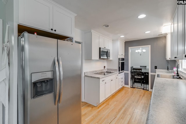 kitchen featuring white cabinetry, appliances with stainless steel finishes, sink, and light hardwood / wood-style flooring