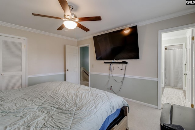 bedroom with ceiling fan, ornamental molding, carpet flooring, and ensuite bathroom