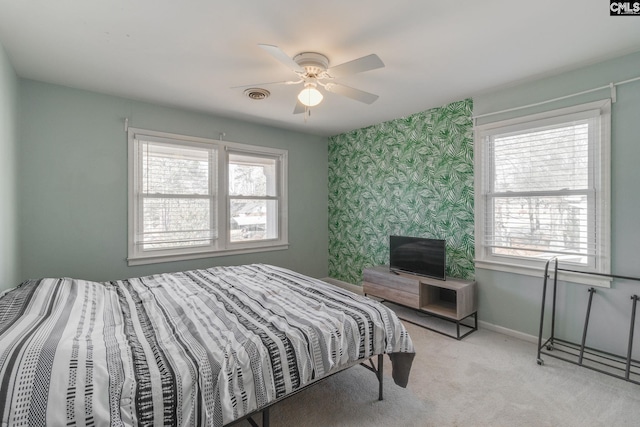 bedroom with multiple windows, light carpet, and ceiling fan