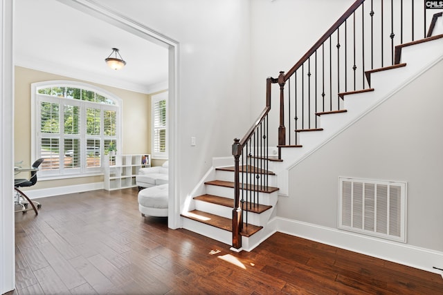 staircase with hardwood / wood-style flooring and ornamental molding