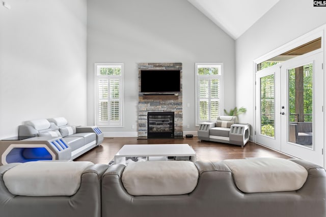 living room featuring french doors, wood-type flooring, a fireplace, and high vaulted ceiling