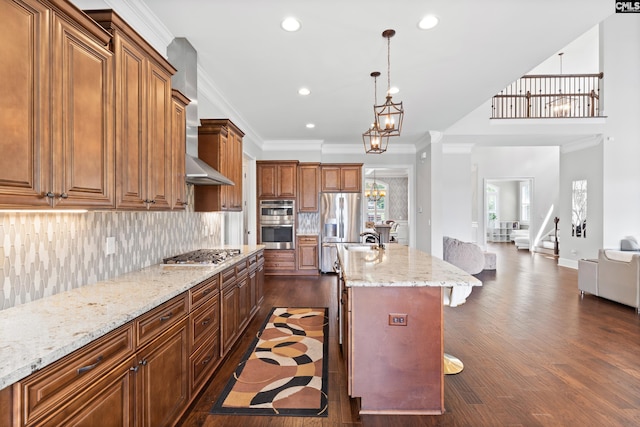 kitchen featuring pendant lighting, appliances with stainless steel finishes, an inviting chandelier, an island with sink, and a kitchen bar