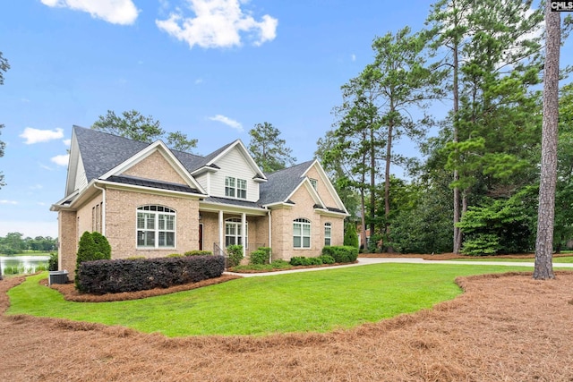 craftsman house with central AC, a water view, and a front yard