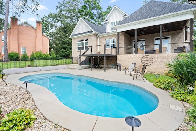 view of swimming pool featuring ceiling fan and a patio area