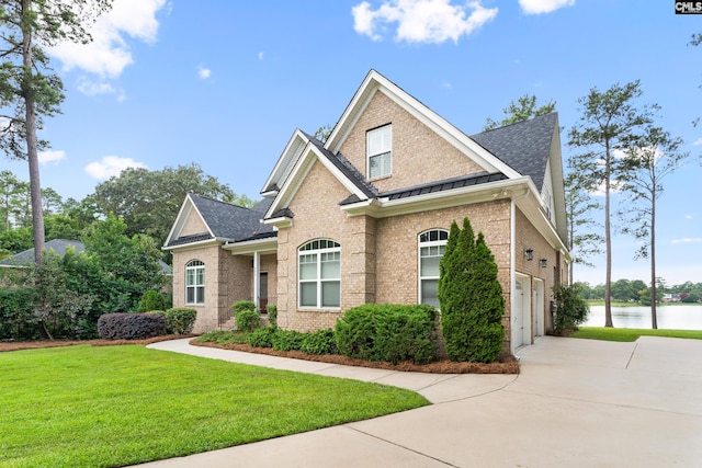 craftsman inspired home with a water view, a garage, and a front lawn