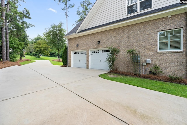 view of side of home with a garage and a yard