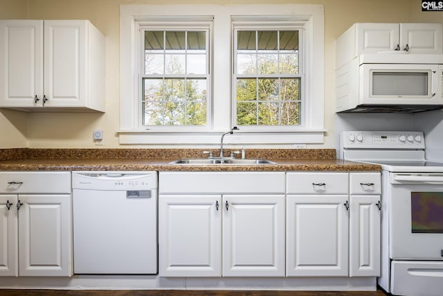 kitchen featuring sink, white cabinets, and white appliances