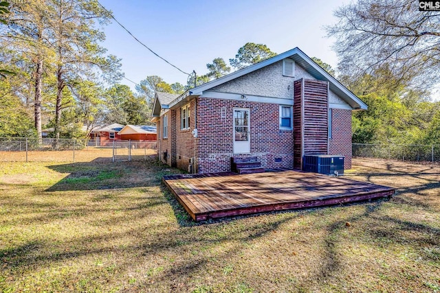 rear view of house featuring a yard, a deck, and central air condition unit