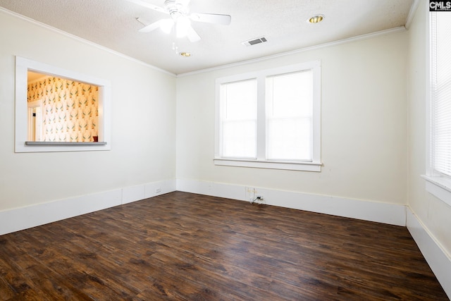 spare room with dark wood-type flooring, ornamental molding, a textured ceiling, and plenty of natural light