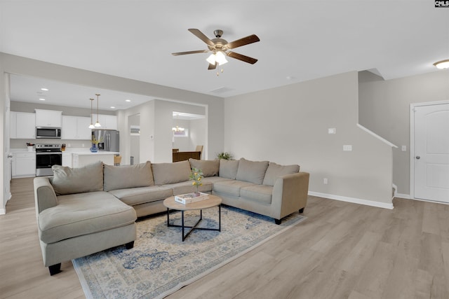 living room with light hardwood / wood-style floors and ceiling fan