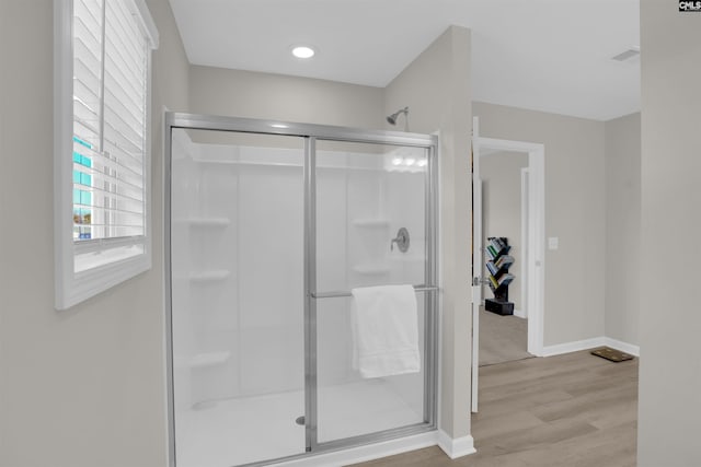 bathroom with hardwood / wood-style flooring and walk in shower