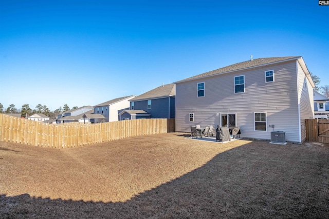 back of house with cooling unit, a patio, and a lawn