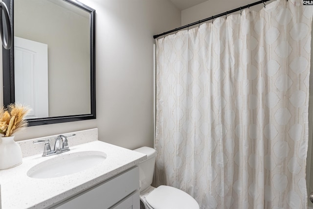 bathroom featuring vanity, curtained shower, and toilet