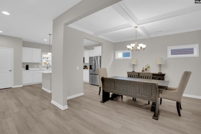 dining area featuring crown molding, coffered ceiling, an inviting chandelier, and light hardwood / wood-style flooring