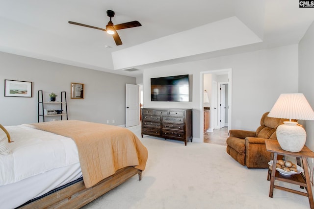 carpeted bedroom with ceiling fan and a tray ceiling