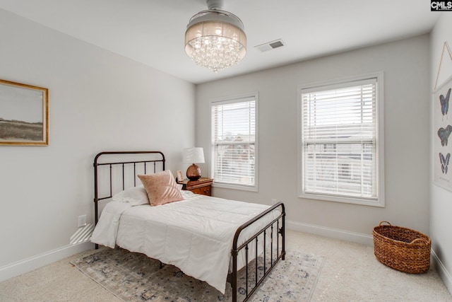 carpeted bedroom with an inviting chandelier