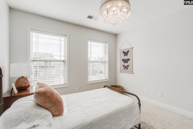 carpeted bedroom featuring a chandelier