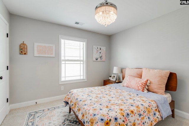 carpeted bedroom with an inviting chandelier