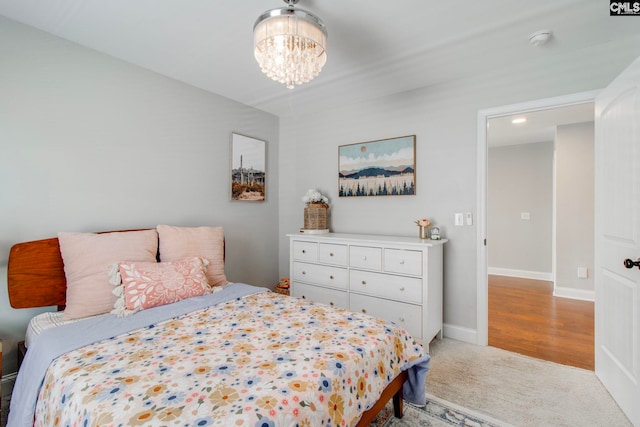 bedroom featuring light colored carpet and a chandelier