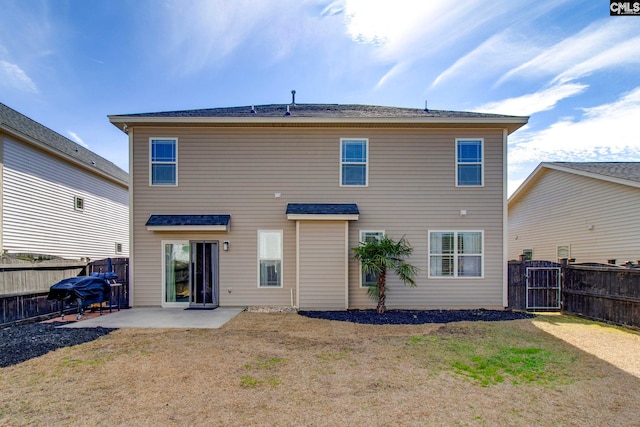 rear view of house featuring a lawn and a patio