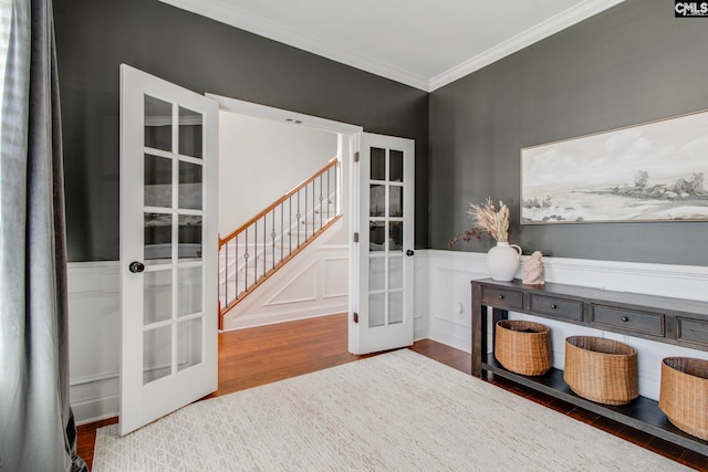 interior space with hardwood / wood-style floors, ornamental molding, and french doors