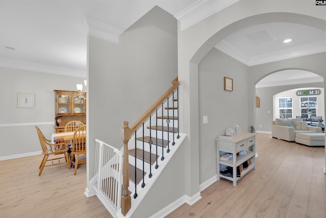 stairway with ornamental molding and hardwood / wood-style floors