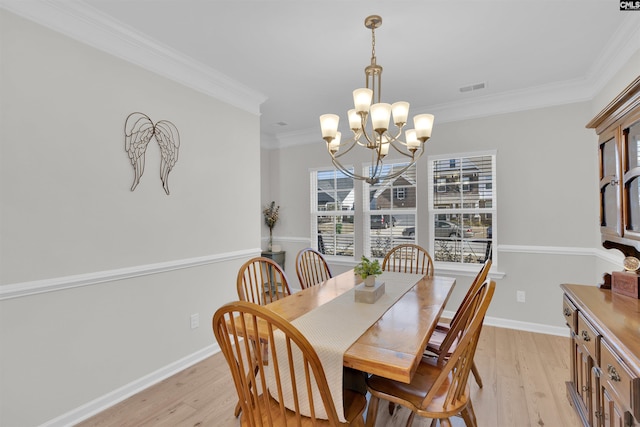 dining space with ornamental molding, a chandelier, and light wood-type flooring