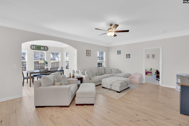 living room featuring ornamental molding, ceiling fan, and light wood-type flooring