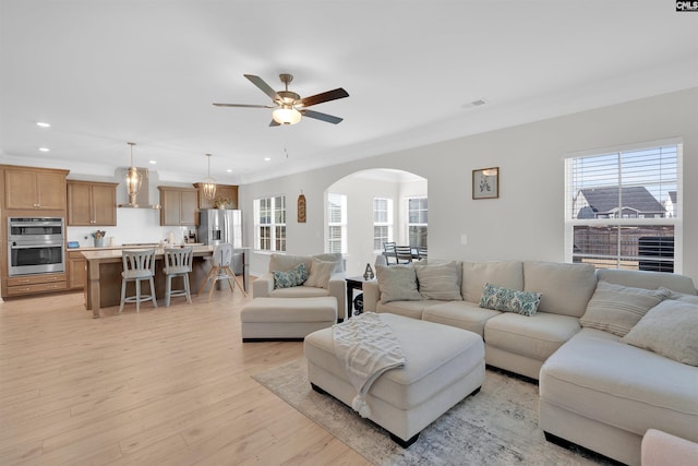 living room featuring crown molding, ceiling fan, and light hardwood / wood-style flooring