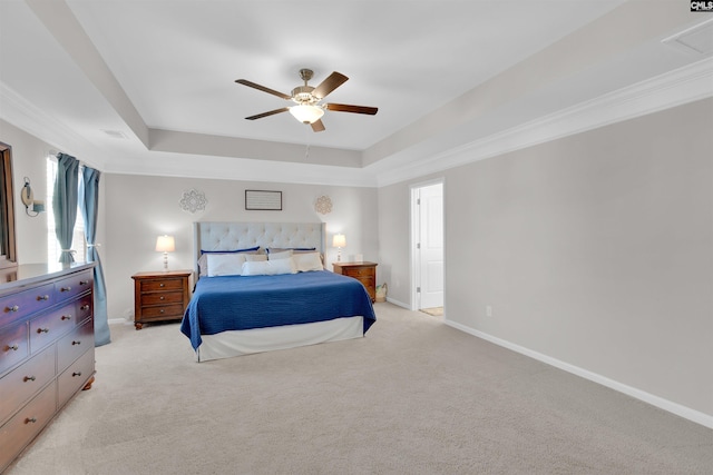 bedroom featuring a raised ceiling, crown molding, light carpet, and ceiling fan